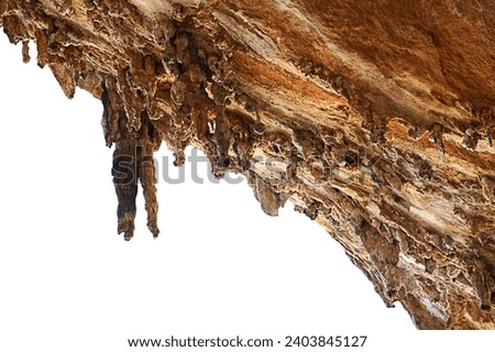 Large stalactites hanging down from open cave ceiling in Grande Grotta on Kalymnos during sunny day