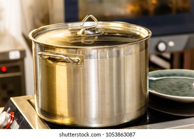 A large steel pot for cooking broth stands on the stove.