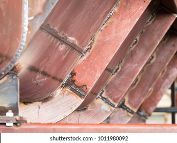 Large steel tank with welded on reinforcement beams under construction. Shallow depth of field with the nearest reinforcement beam in focus.