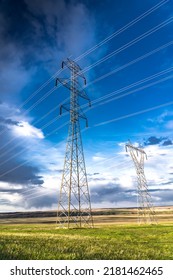 Large Steel Transmission Towers Standing Tall Providing Electricity And Rural Internet To Alberta Residents Along Prairie Agriculture Fields In Rocky View County Canada.