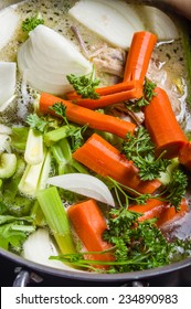 A Large Stock Pot On A Stove With Vegetables Cut For Making Soup