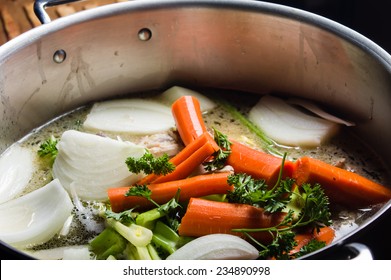 A Large Stock Pot On A Stove With Vegetables Cut For Making Soup