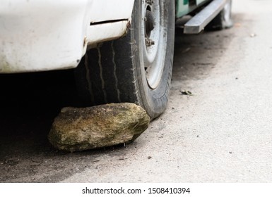 Large stone behind a wheel of a car - No faith in the brakes