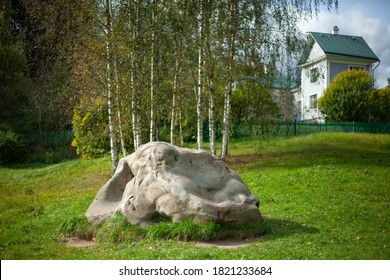 Large Stone On The Lawn. The Boulder Lies On The Green Grass In The Yard. Landscaping Of A Natural Slope. A Beautiful Stone. Cobblestone On The Estate.