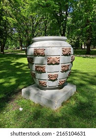 Large Stone Vase Is Set On Large Green Lawn In The Park