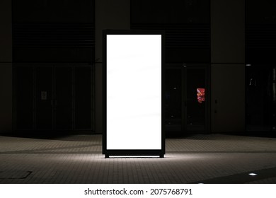 Large Street Portrait Advertisement Billboard Placed Outside During Night Time. Tall Outdoor  Blank Digital Signage Light Box Mock Up Ideal For Posters, Huge Information Boards.