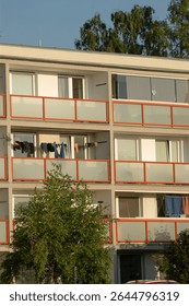 A large structure featuring numerous windows and a variety of balconies that provide outdoor space for the residents inside