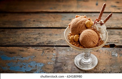 Large Sundae Bowl With Chocolate Ice Cream And Various Toppings Over Old Weathered Wooden Table Background