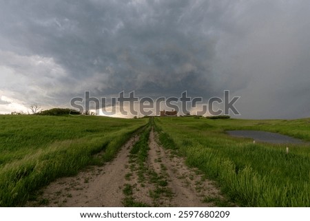 Large supercell thunderstorm is developing over a farmhouse in the great plains