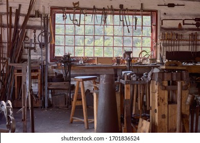 large table by the window Old vintage craftsman's workshop blacksmith with a jaw vise and other tools