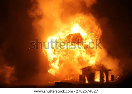 Large tactical explosion and fireball blast near a structure during a military night training exercise.