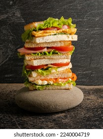 Large tall stacked multiple layer sandwich. isolated on black background