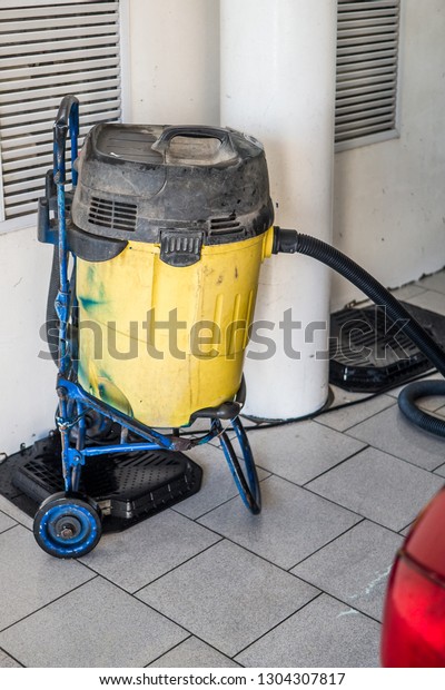 Large technical vacuum cleaner yellow at the\
car wash. Professional\
application