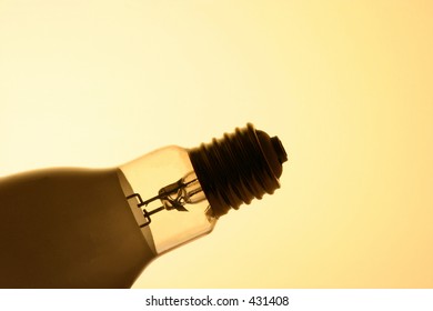 A large thread bulb silhouetted in front of a yellow background