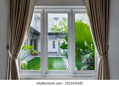 Large Three Pane Window Looking On Summer Backyard With Tropical Garden