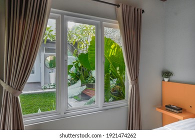 Large Three Pane Window Looking On Summer Backyard With Tropical Garden