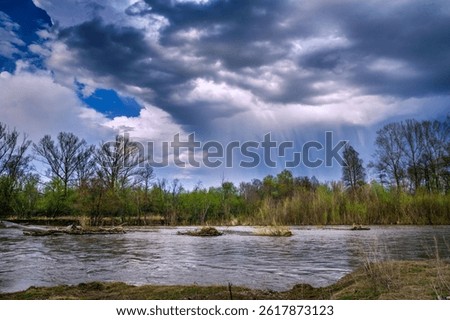 a large thundercloud over the Ural River during the spring flood
