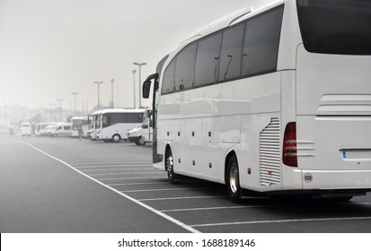 большой туристический автобус едет вдоль припаркованных микроавтобусов