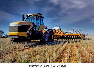 A Large Tractor With Seeder Plowing Along Side By Side Last Year Rows And No Tillage.