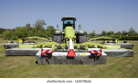 Large Tractor With Several Disc Mower Attachment.