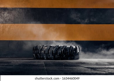 A large tractor wheel for crossfit lies on the floor in the gym. Sports equipment - Shutterstock ID 1634460049