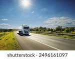 Large Transportation Truck on a highway road through the countryside at sunset