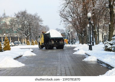 A Large Truck Removes Fresh Snow From A Snowy City Street In Winter. A Big Utility Truck Cleans The Street In The Cold Season. Dnepropetrovsk, Ukraine