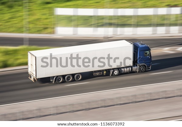Large truck with a trailer on\
the highway at a speed that moves along the asphalt, view from\
above