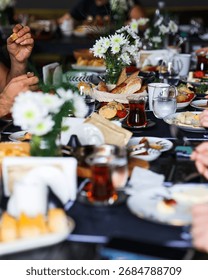 Large Turkish breakfast table set with bread, tea, cheeses, and assorted dishes