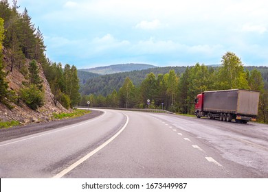 a large van stands on the side of the road among the mountains of the Urals and forests, transporting goods