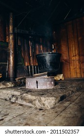 A Large Vat In Which Cheese Is Cooked Over An Open Fire. The Black Cauldron Is Prepared Over An Open Wood Fire. Cheese Factory In The Mountains.