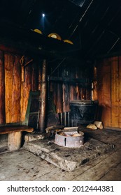 A Large Vat In Which Cheese Is Cooked Over An Open Fire. The Black Cauldron Is Prepared Over An Open Wood Fire. Cheese Factory In The Mountains.