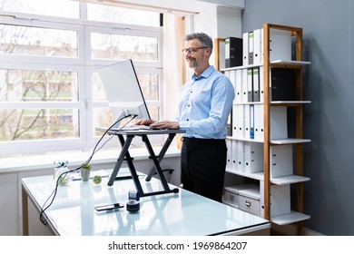 Large Version Of Adjustable Height Desk Stand In Office Using Computer