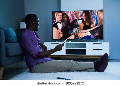 Large Version Of African Man Watching TV Movie Or Television