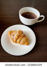 large vertical photo. breakfast. view from above. white chinaware. Black coffee with almond croissant. Homemade baking.