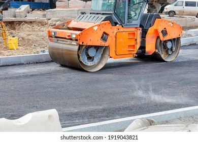 Large Vibratory Roller Compact Fresh Asphalt On The Road Surface Of A New Construction Site. Copy Space.