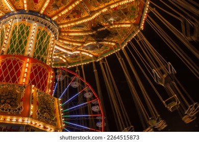 Large and victorian decorated carnival ride with swings at night