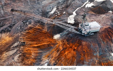 A large walking excavator works in a quarry for the extraction of rare metals. Drone view. Industrial landscape. - Shutterstock ID 2246154537