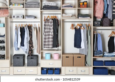 Large wardrobe closet with different clothes and home stuff