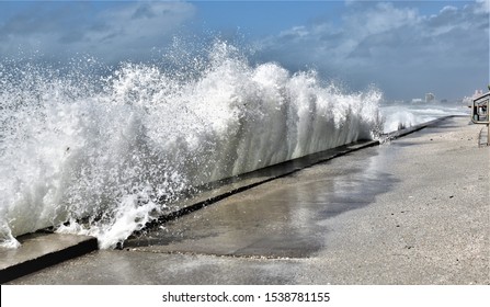 Large Wave Is Crashing Into Beach Wall During A Stormy Day In A St.Pete Beach N Florida During Nestor Showing Rising Sea Levels Due To GLobal Warning Threaten Beach Goers.