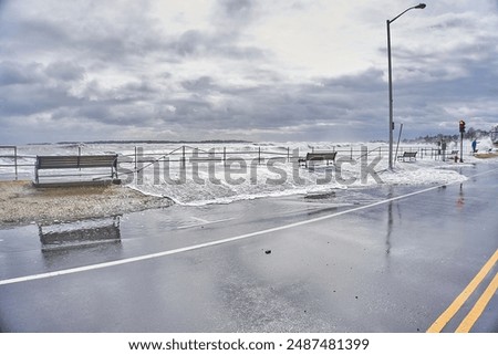 Large waves at high tide causing damage and flooding of the sidewalk and streets 