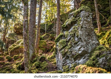 Large Weathered Granite Rock In The Shape Of A Human Head With Eyes Ears Mouth And Nose Overgrown With Moss On The Mountain Hoher Sachsen Near Grafenau In The Bavarian Forest, Germany