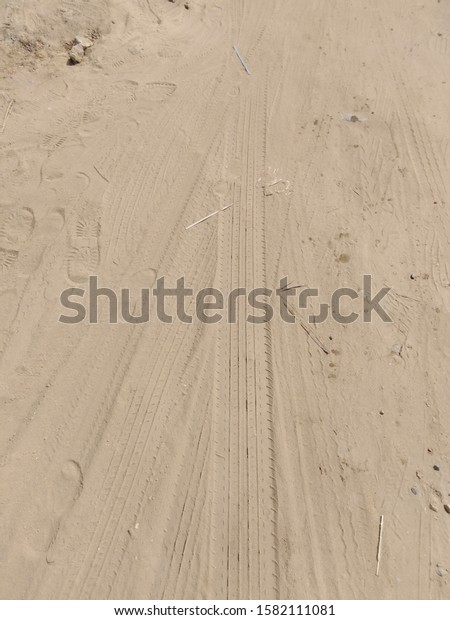 Large wheel marks on\
sand.