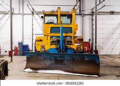 Large Wheeled Tractor With A Dozer Blade For Clearing Roads From Snow