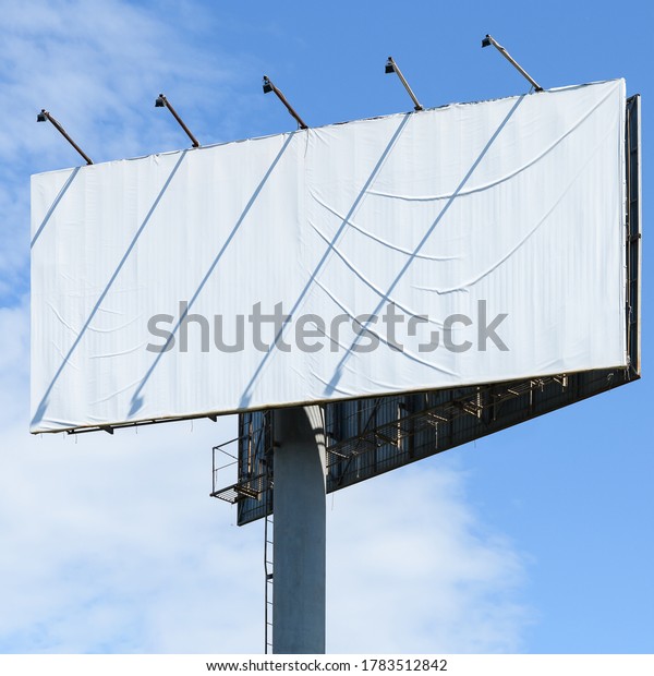 Large white billboard on the street in the\
city on a sunny day close up. Copy\
space