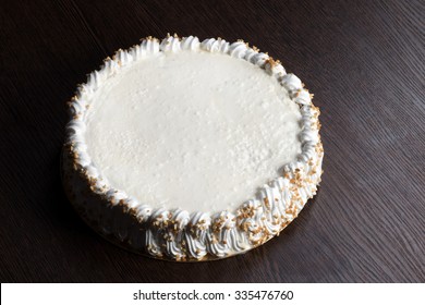 Large White Cake With A Blank Top On A Wooden Table