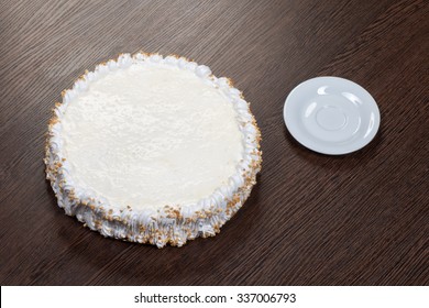 Large White Cake With A Blank Top On A Wooden Table