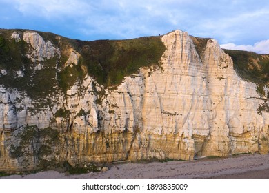 Large white cliffs with two small figures standing on the top.