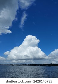 A large white cloud over a river 