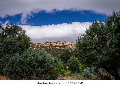 Large white clouds overhang distant mountains in the Granite Mountain Recreation area of Prescott, Arizona.